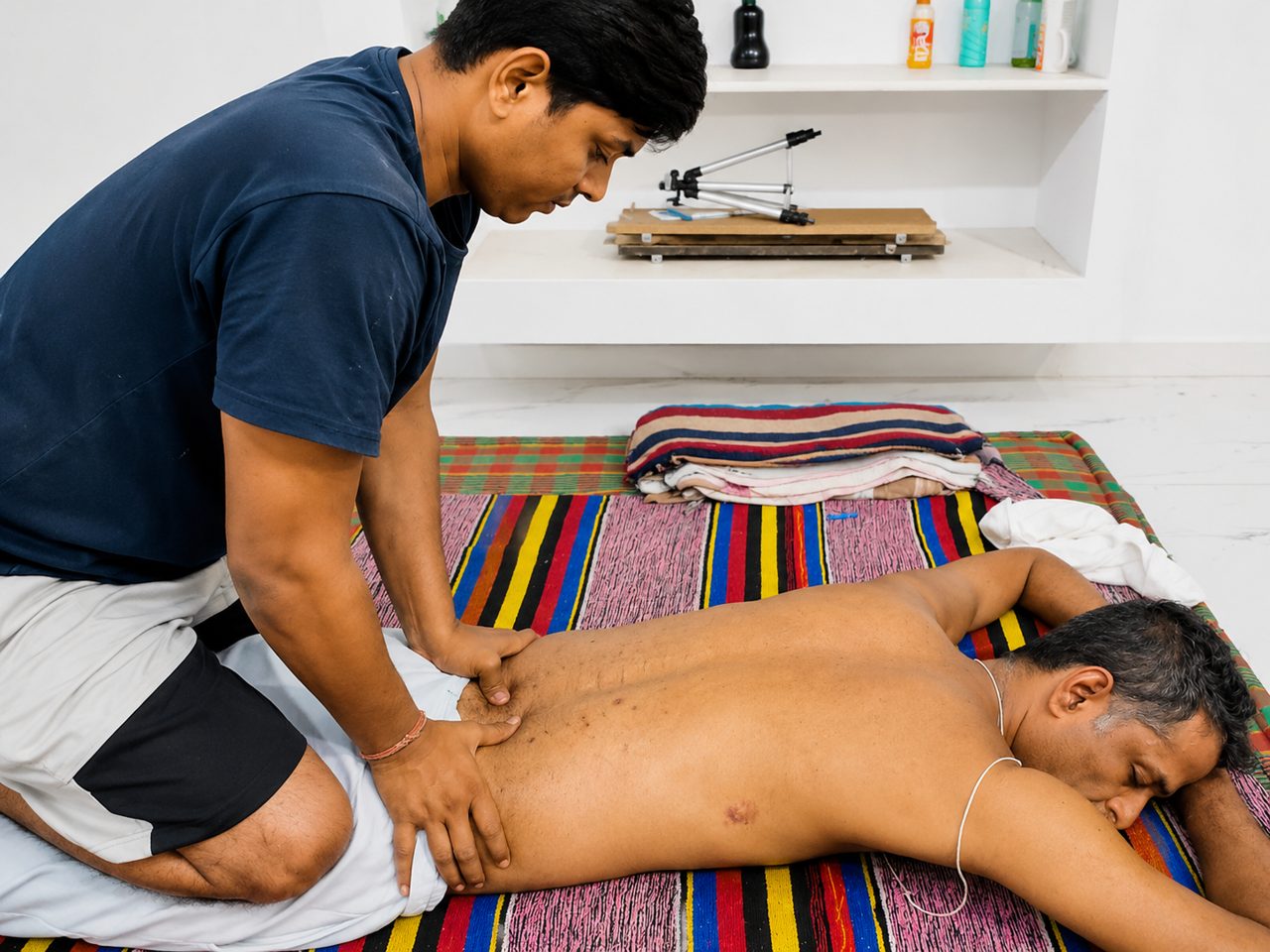 Student practising a back massage technique under supervision at Nirvana School