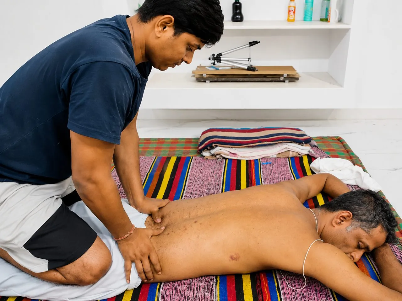 Student practising a back massage technique under guidance during practical training at Nirvana School of ThaiMassage & Yoga, Gaya