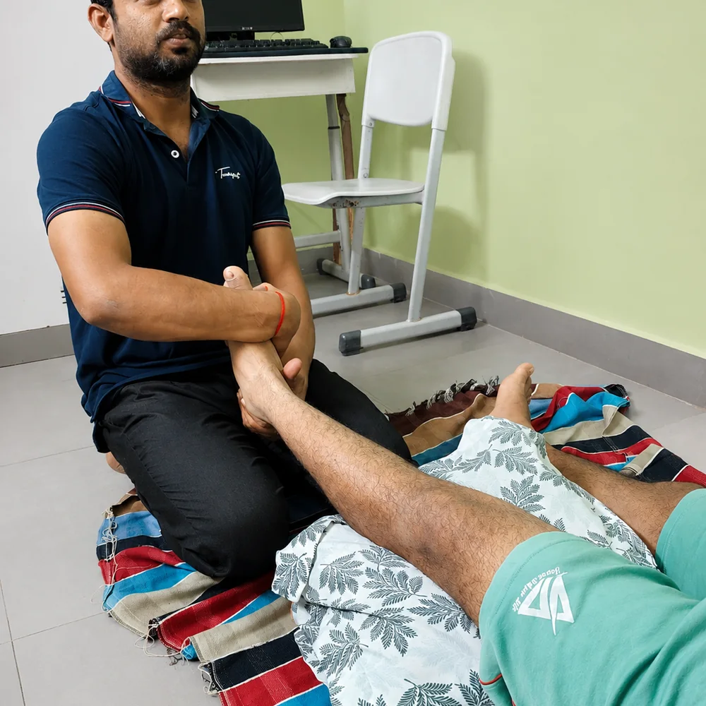 Thai massage leg pull technique practice during hands-on training at Nirvana School of ThaiMassage and Yoga in Gaya