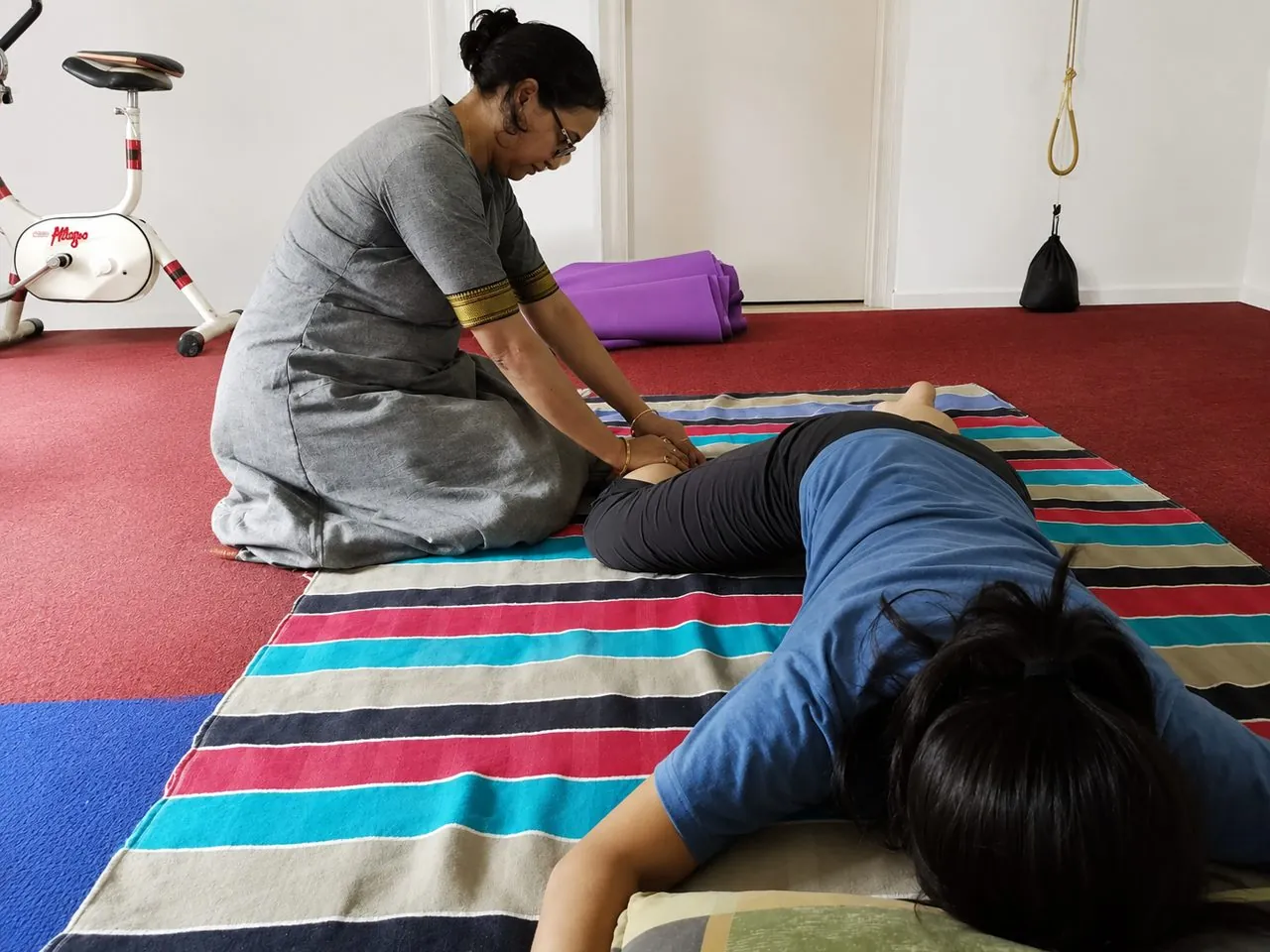 Female instructor demonstrating a therapeutic back and spine massage technique during curriculum training at Nirvana School of ThaiMassage & Yoga, Gaya