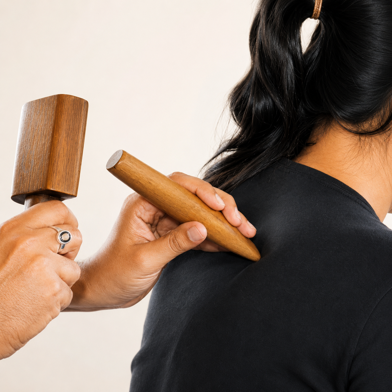 Tok Sen Thai massage wooden tools used on shoulder during training at Nirvana School